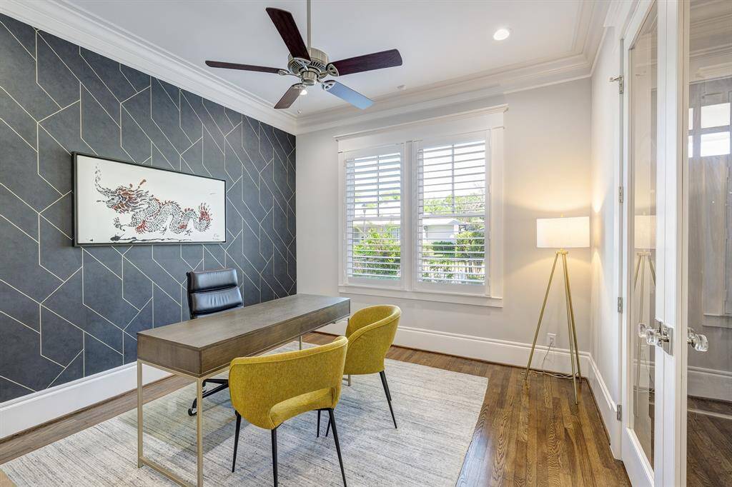 The versatile 1st-floor study, which can also serve as a 5th bedroom, features custom wallpaper and glass doors that open to the entry, adding both style and functionality.