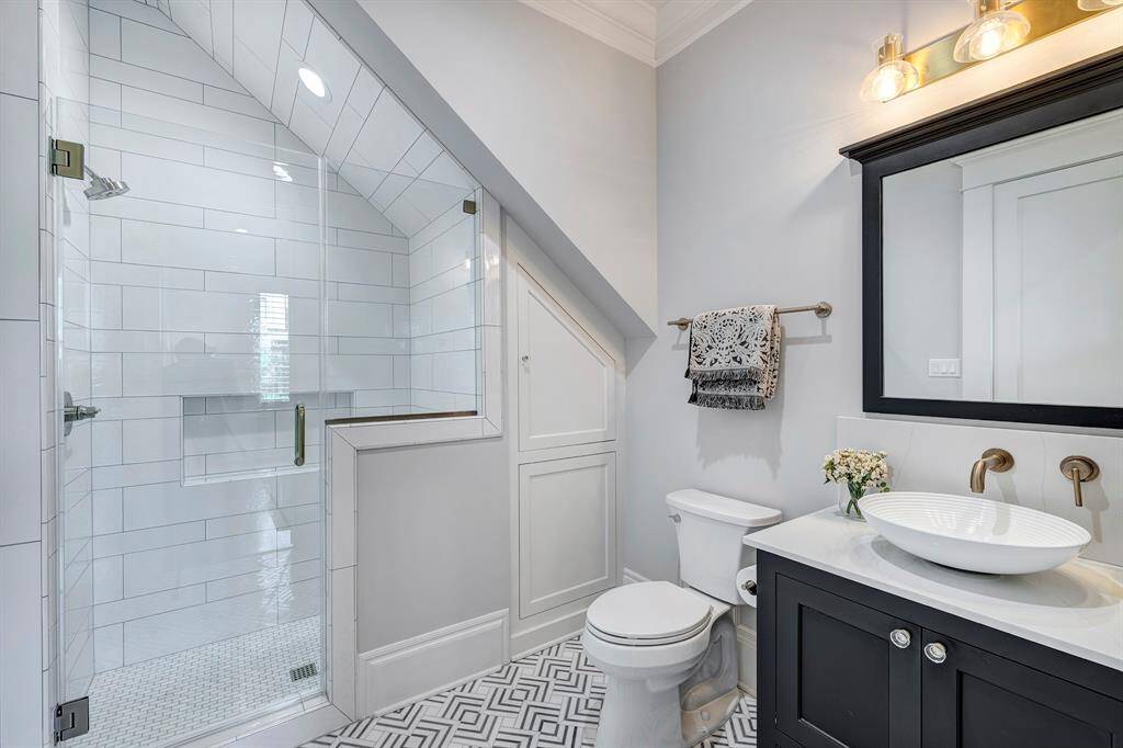 Convenient 1st floor bathroom features a walk-in shower, ample storage, and sleek modern finishes.