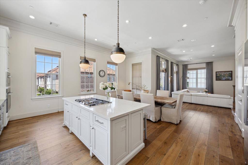 The kitchen and dining area are filled with top-tier upgrades—quartzite island, marble backsplash, stainless steel countertops, and designer pendant lighting. Every element reflects thoughtful design and craftsmanship.