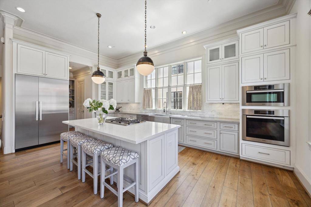 High-end Miele appliances include a stainless steel refrigerator, gas cooktop, traditional oven, speed oven, and dishwasher.