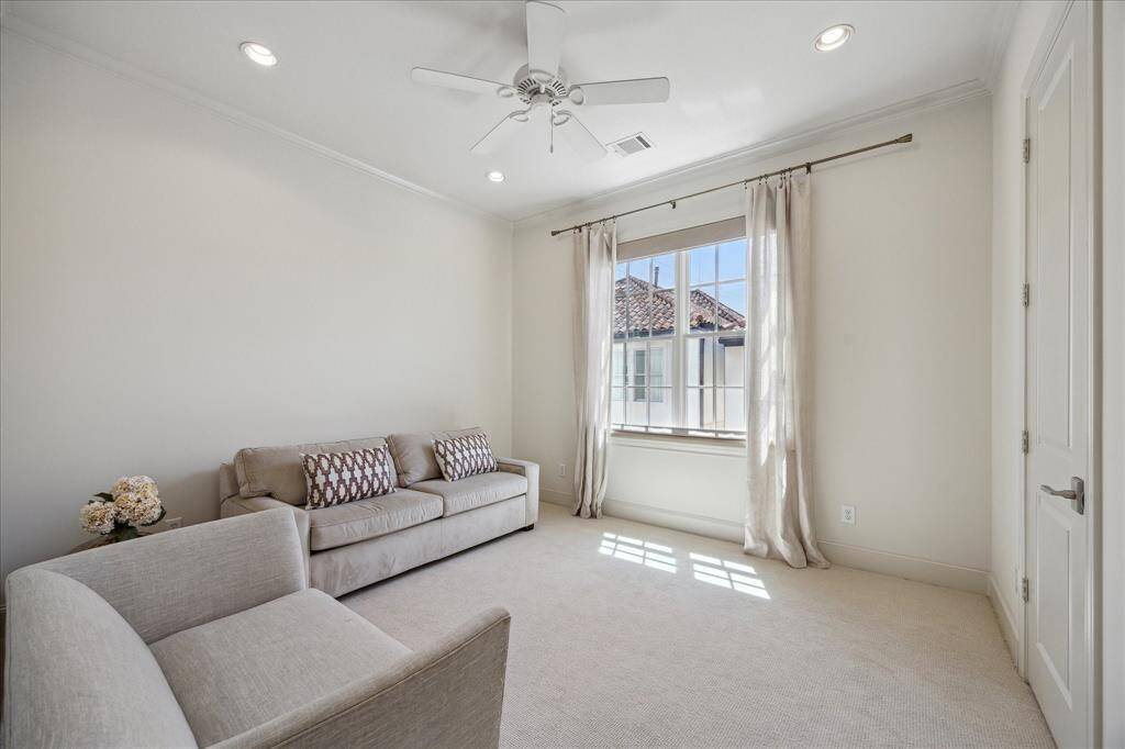 The primary bath leads to a custom-designed walk-in closet. Soft window treatments and limestone counters with undermount sinks offer both style and serenity. The freestanding soaking tub invites peaceful relaxation.