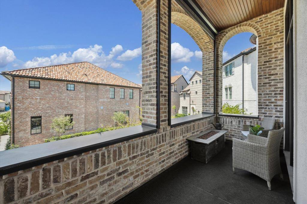 Located just off the game room, the expansive rooftop terrace offers plenty of space for entertaining or relaxing. A wood-look deck and beadboard ceiling elevate this low-maintenance, zero-lot line property.