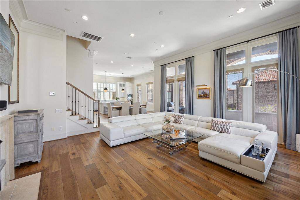 The dining space is bathed in sunlight and positioned near the doors leading out to the balcony.