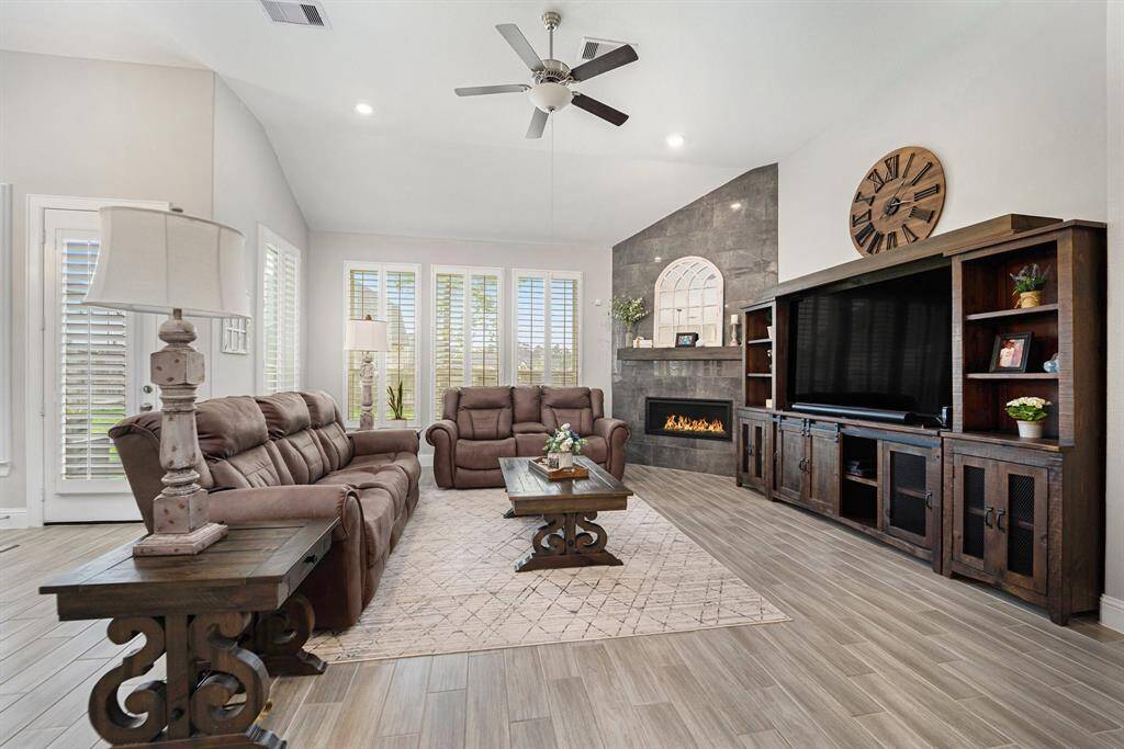 Stunning living room with high ceilings, an elegant fireplace, and great views of the backyard.