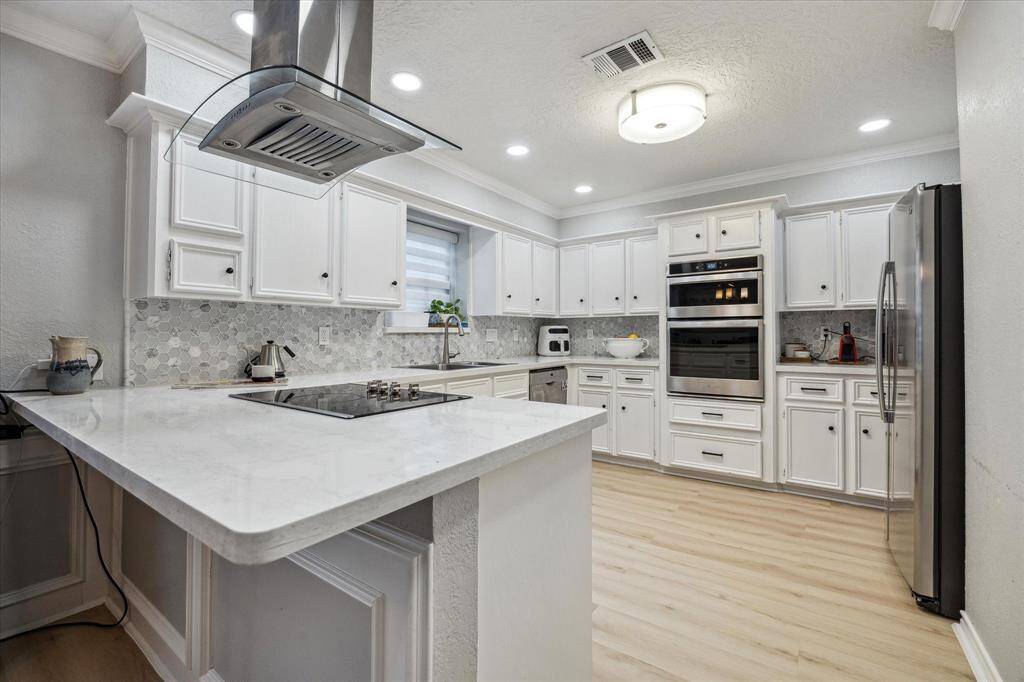 The kitchen sparkles with recent* stainless steel appliances, quartz countertops and complementary tiled backsplash.  *2023 per seller