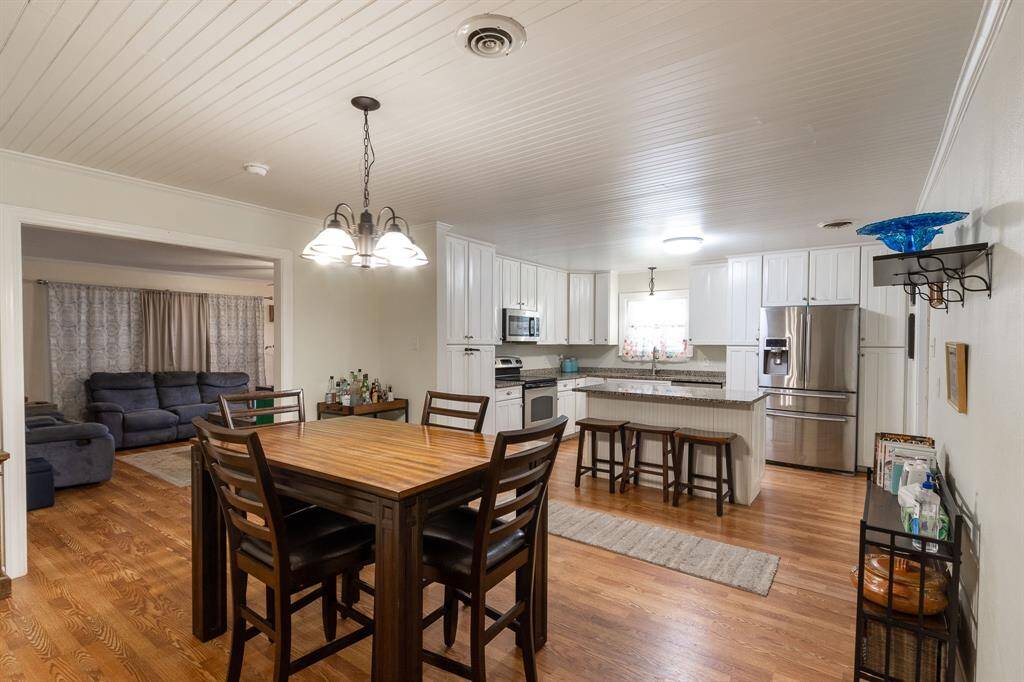 Dining area in the foreground, kitchen in the background and living room in the background to the left.  Beautiful wood floors.