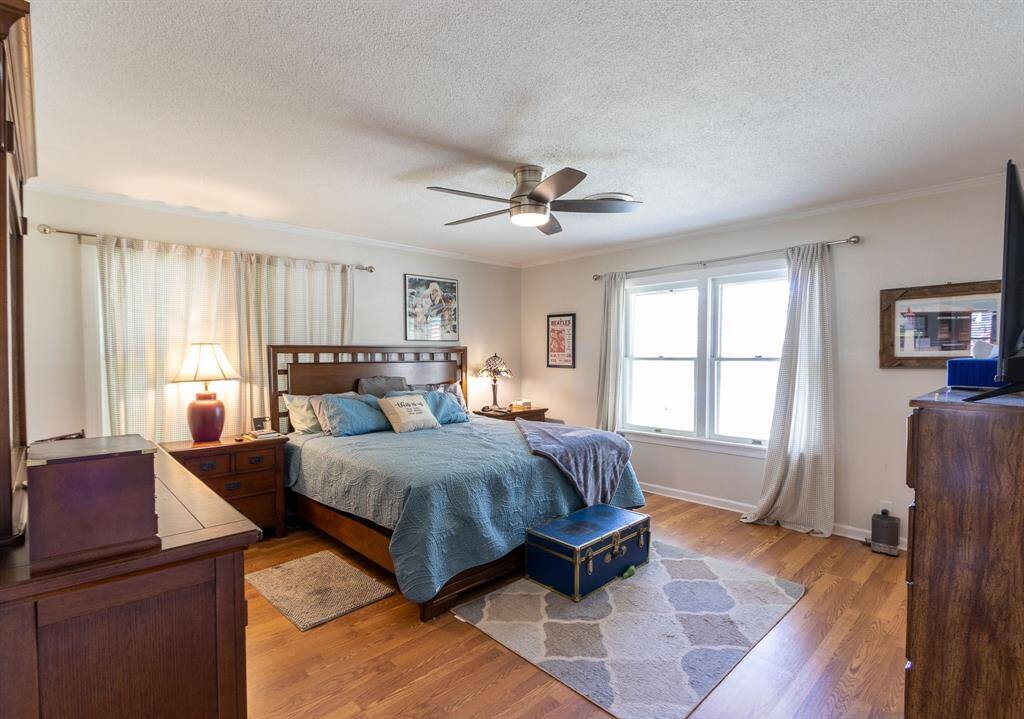 Primary bedroom. Beautiful wood floors, baseboards and crown molding.