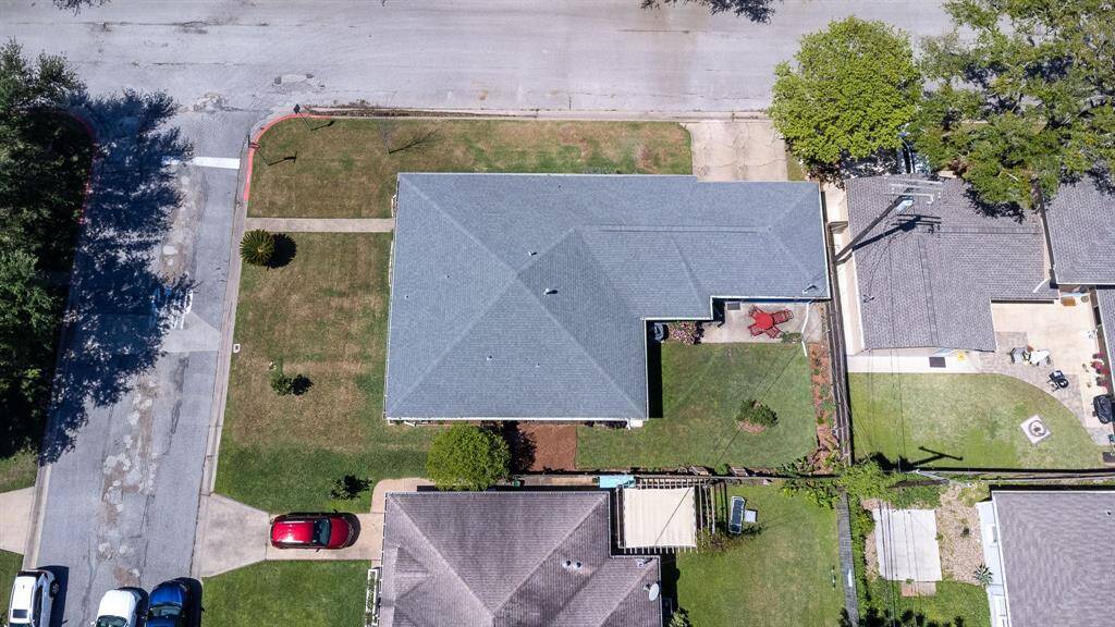 Aerial view of the house showing Dolphin Avenue on the left. Fenced backyard. Driveway accessing Marine Drive.