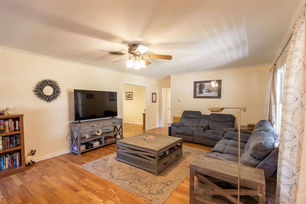 Looking from the front door into the living room with dining area in the left background and hallway to 2 bedrooms and hall bath to the right.