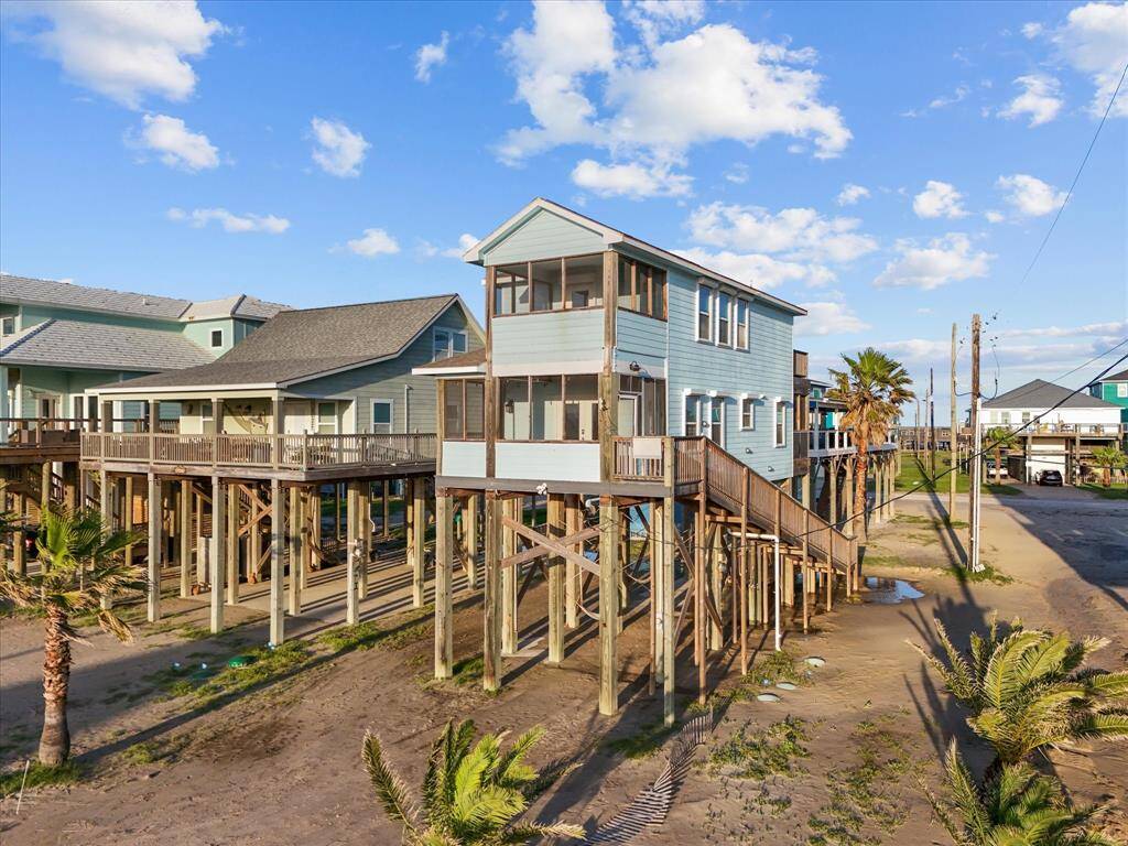 Elevated beach home with a spacious deck and ocean views, featuring a charming coastal design and easy access to sandy shores. Perfect for enjoying seaside living.