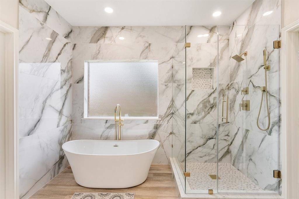 Frameless glass encloses the shower with multiple jets! Melt your worries away in a gorgeous free standing tub!