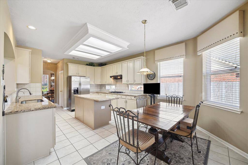 EXPANSIVE EAT-IN KITCHEN BOASTS STAINLESS STEEL APPLIANCES AND PLENTY OF COUNTERSPACE.