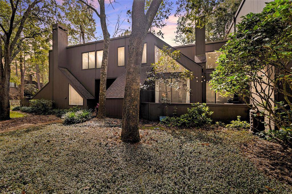 A striking multi-level home with a distinctive architectural design offers expansive windows that invite natural light, while the rich natural wood exterior blends seamlessly with the surroundings. Nestled among mature trees and thoughtfully landscaped with lush shrubs, this home offers a tranquil, private retreat.