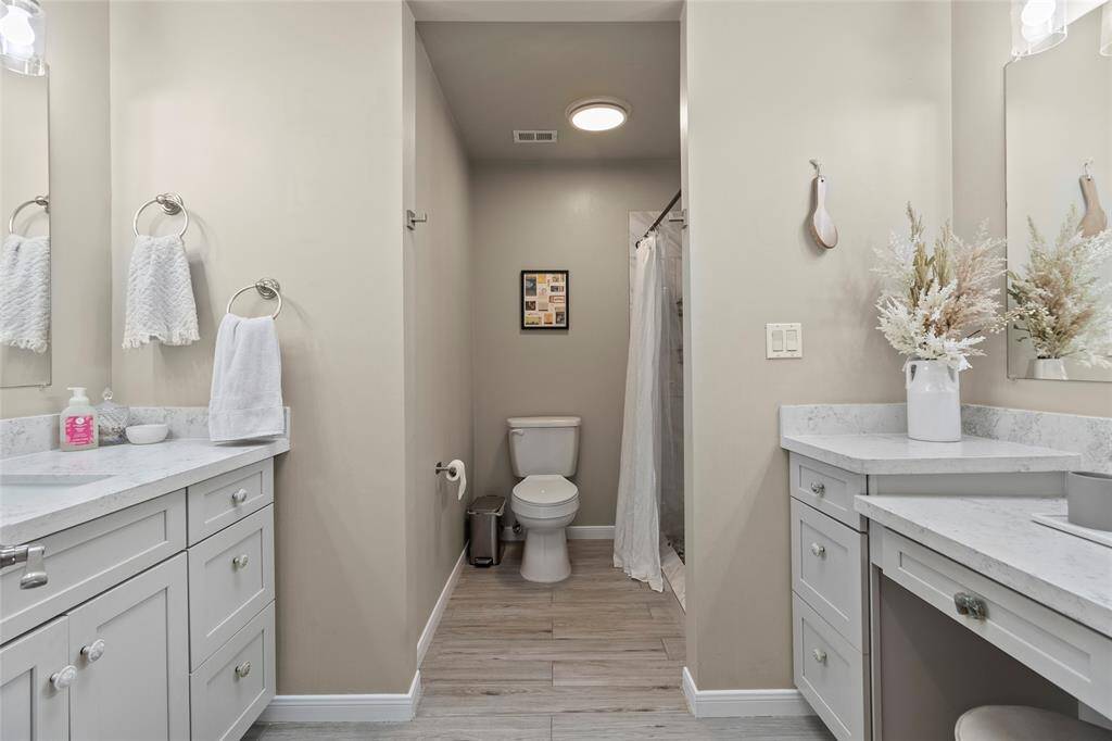 The primary bathroom features a clean, modern design with neutral tones complete with dual vanities offering ample storage!