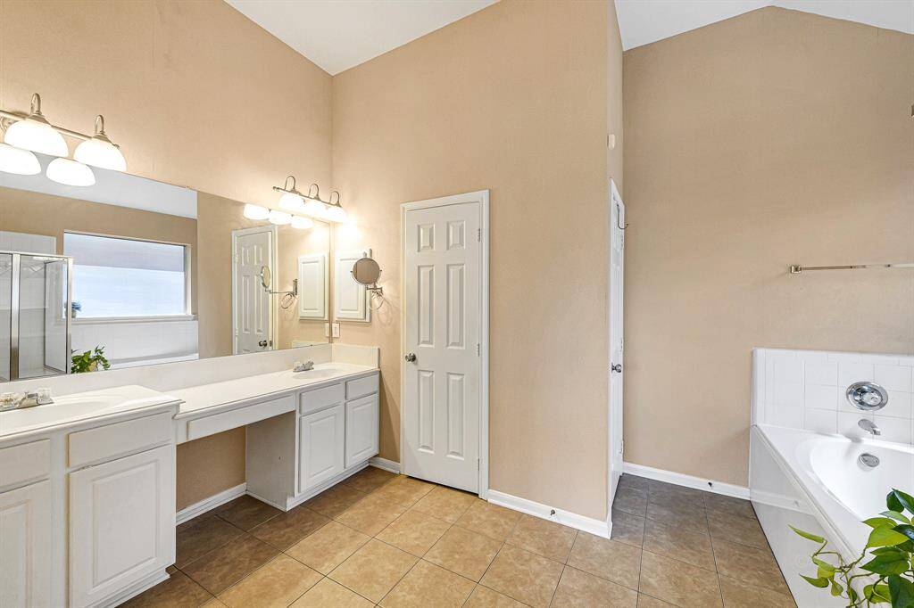 Through the double doors, you'llenter your luxurious primarybath, where vaulted 11-footceilings create an open and airyfeel. A spacious 7-foot vanitywith dual sinks offers plenty ofunder-cabinet storage, while adeep linen closet providesadditional space. Brushed nickelsconces add a touch ofelegance, perfectly illuminatingthe space and enhancing itsserene atmosphere.