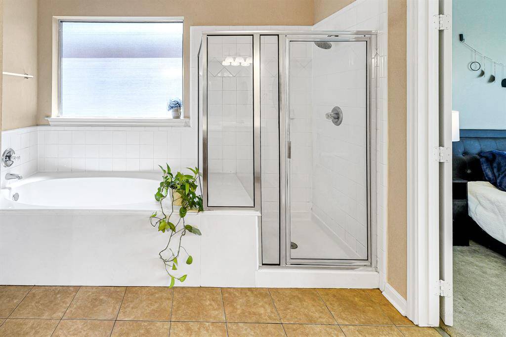 The soaking tub is positionedbeneath an obscure window,allowing natural light to gently fillthe space without compromisingprivacy. The separate tub andshower are beautifully accentedwith crisp white tile surrounds.