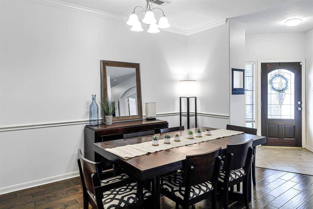 With ample space to accommodate seating for six and a china hutch, this area is perfect for hostinggatherings. A brushed nickel chandelier casts a warm glow, while an elegant archway framesthe space beautifully.