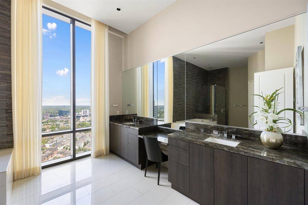 The impressive en-suite bath offers dual sinks, designated vanity space, a glass enclosed shower and soaking tub.