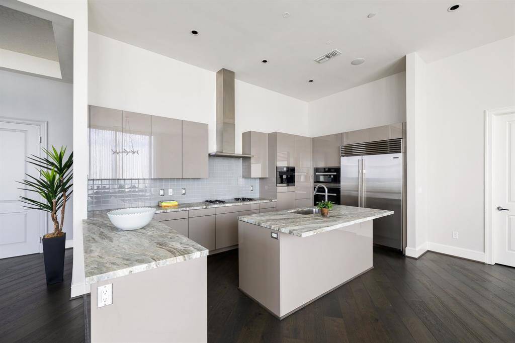 The sleek chef's kitchen offers Miele appliances, breakfast bar seating and a walk-in pantry.