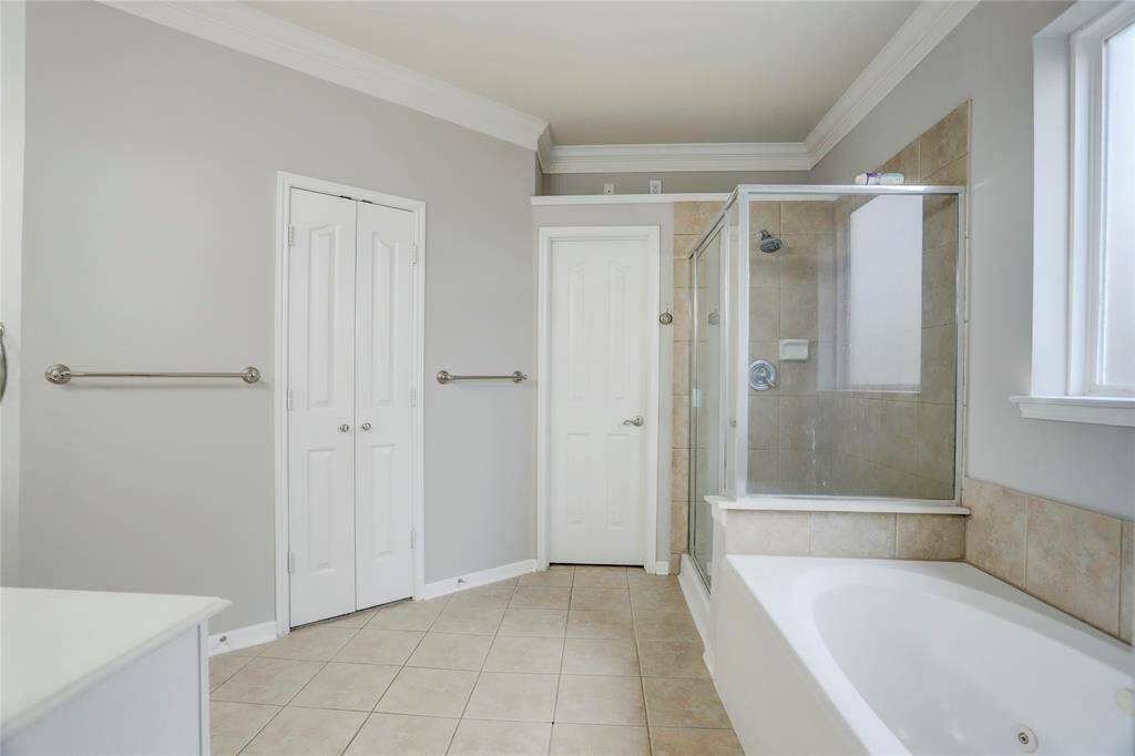 SPACIOUS PRIMARY BATHFEATURING A SOAKING TUB,SEPARATE GLASS SHOWER,AND A WALK-IN CLOSET FORAMPLE STORAGE.
