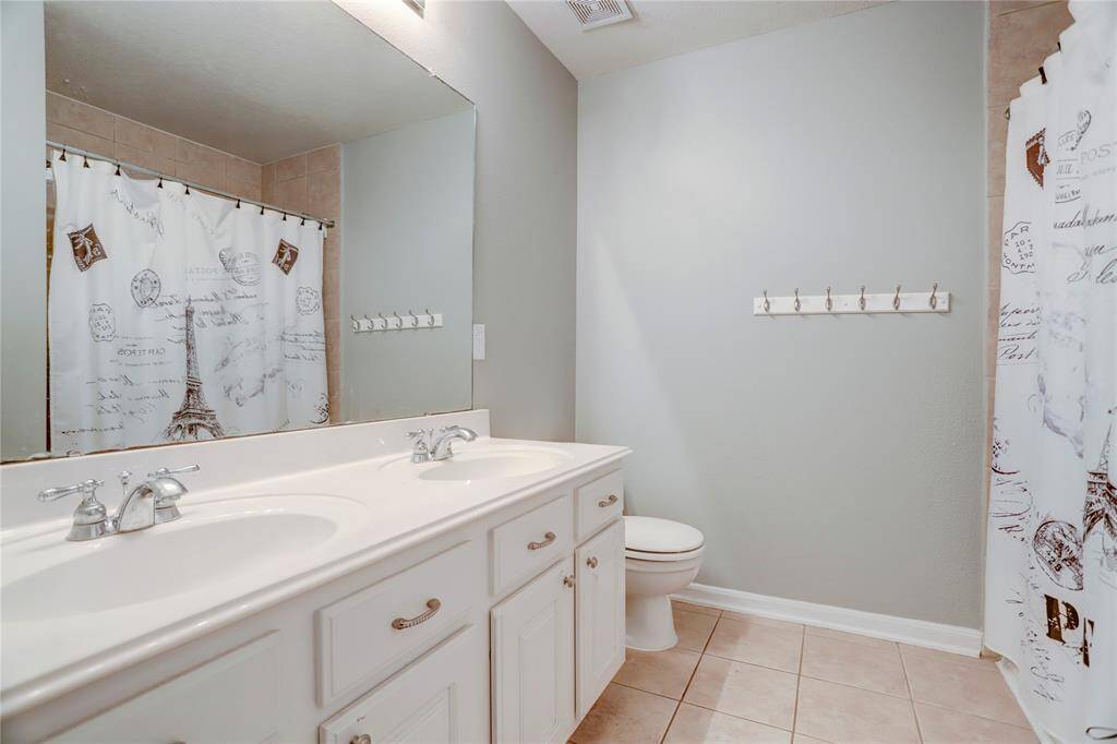 SECONDARY BATHROOMFEATURING DUAL SINKS ANDA NEUTRAL PALETTE FOR AFUNCTIONAL AND ELEGANTSPACE.