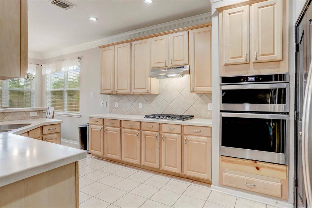 SPACIOUS KITCHEN WITH AGAS COOKTOP, AND PLENTYOF COUNTER SPACE FORMEAL PREP ANDENTERTAINING.