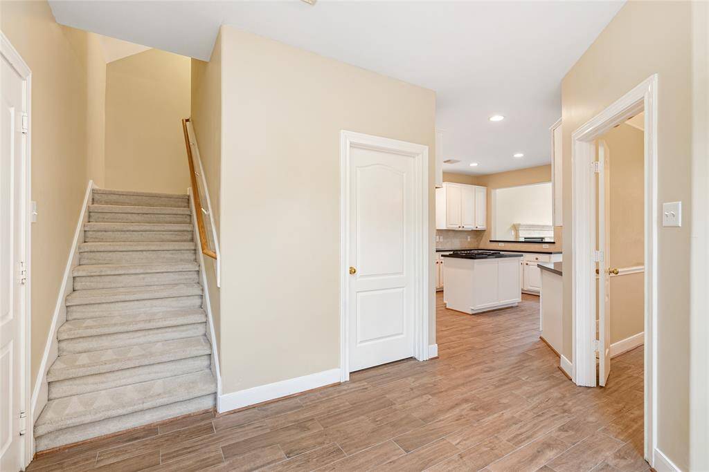 The second staircase leads to the enormous game/flex/family room. The door to the utility room can be seen, where the owners added shelving for extra storage.