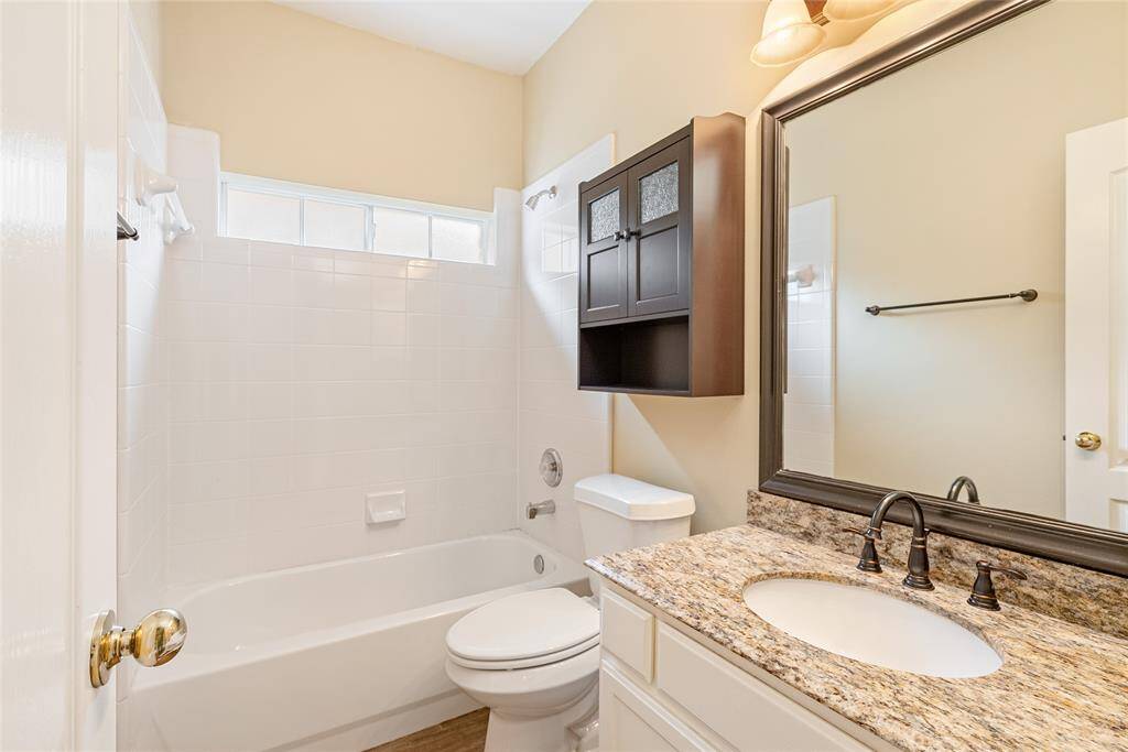 An updated full bathroom downstairs with added shelving for visiting guests.