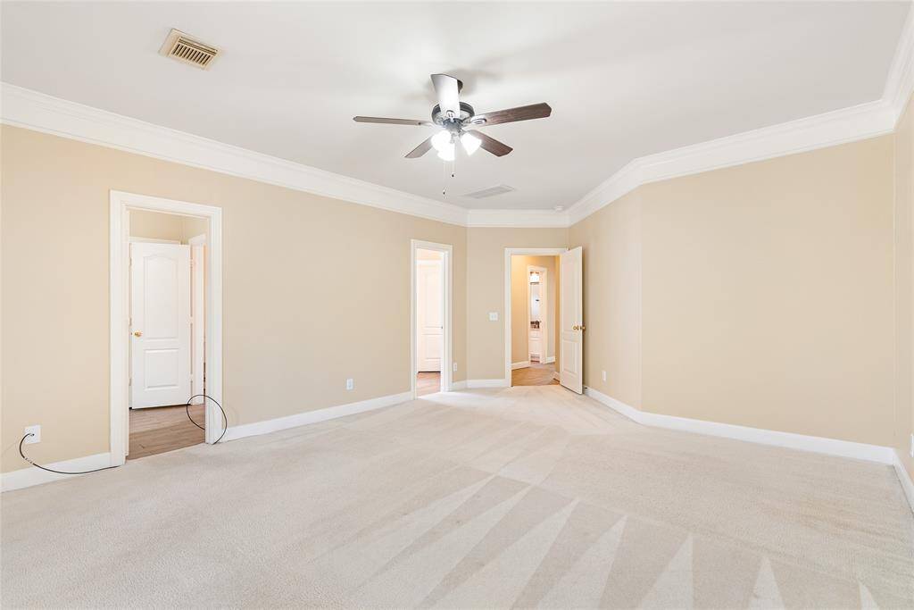 The primary bedroom has a separate door for each person to enter the bathroom, which has individual washrooms and walk-in closets, where the owners added shelving for extra storage.