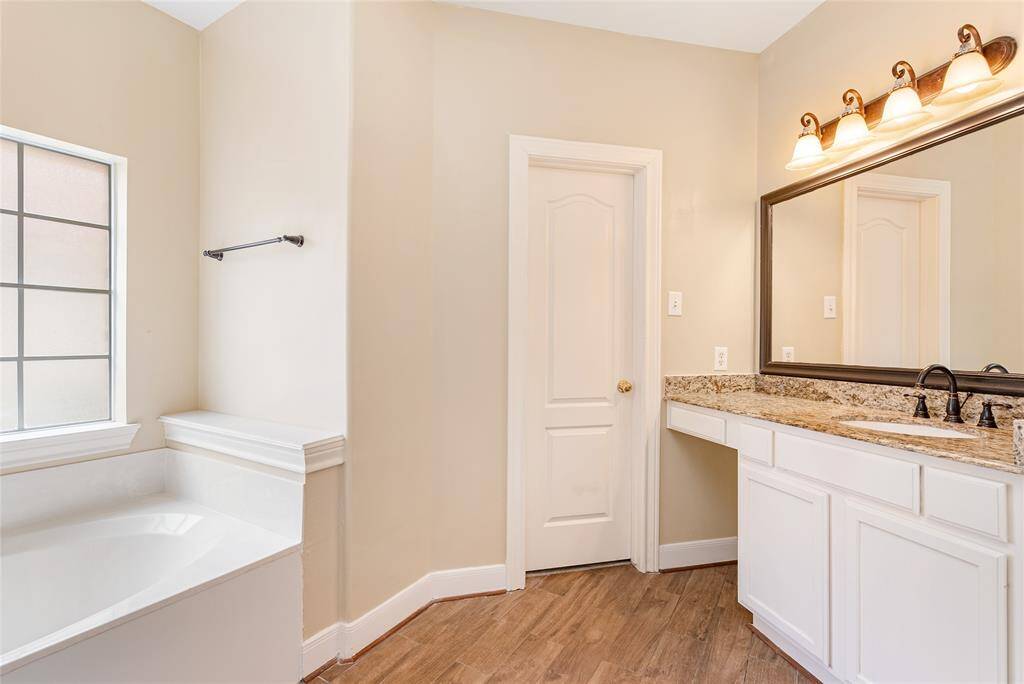 This is one of the updated sides of the primary bath, which includes a vanity area and spa tub. No more vying for space when one is dedicated just for you!
