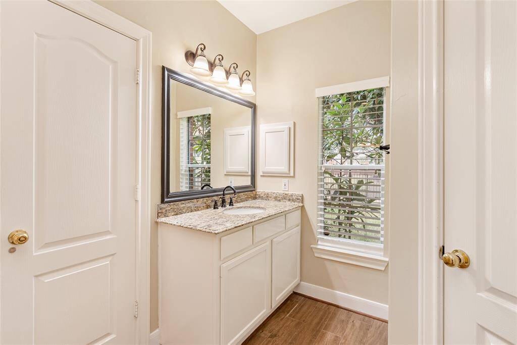 This is the other updated side of the primary bathroom, which overlooks the lake, mature oaks, kumquat trees, and pool.