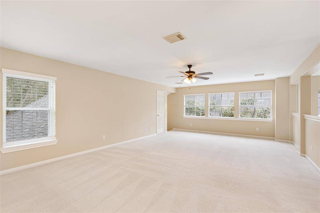 This is a different view of the game/flex/family room, where kumquat trees provide a picturesque backdrop. The door in the background leads to an enormous space the owners created for additional storage.
