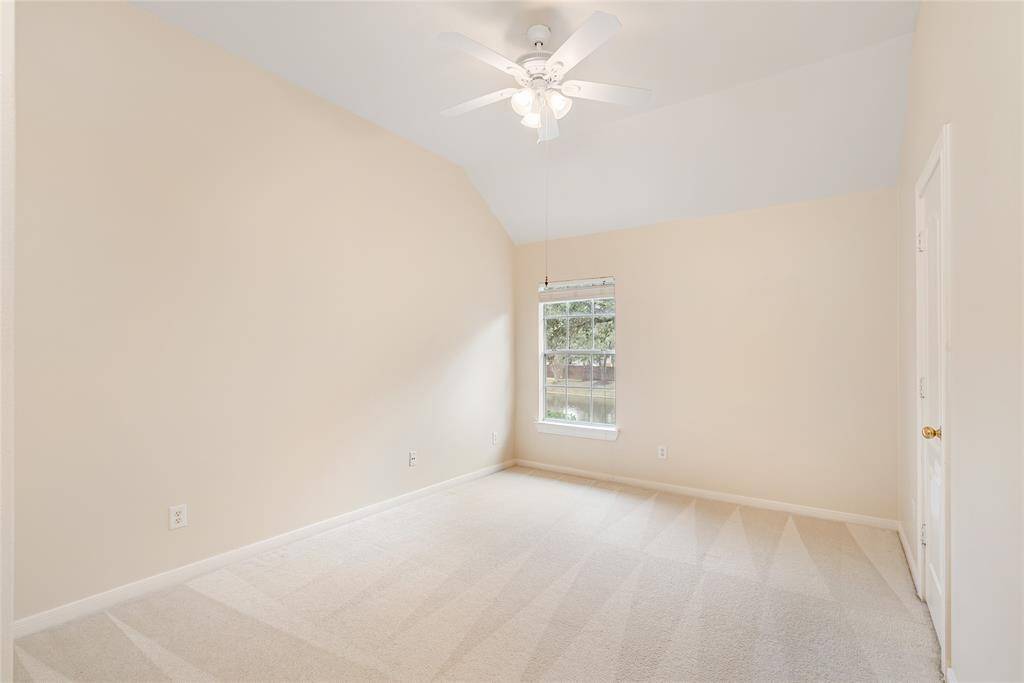 One of the three spacious upstairs bedrooms; this one overlooks the trees, lake, and pool. The high ceilings can easily accommodate bunk beds!