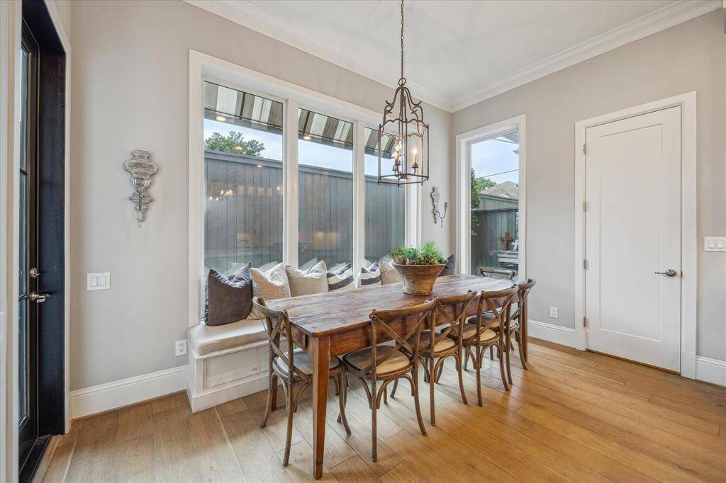 Dining area with a wall of windows overlooking the backyard