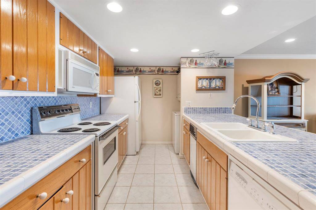 The kitchen is equipped with appliances, including a stackable washer and dryer.