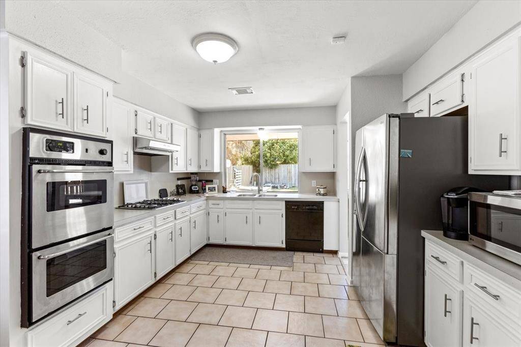 A nice sized kitchen with a double oven and a new gas stovetop.