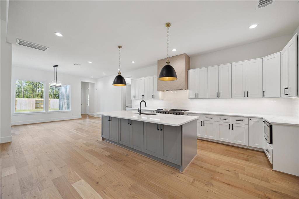 Kitchen with custom cabinetry, massive island with seating, and high end finishes