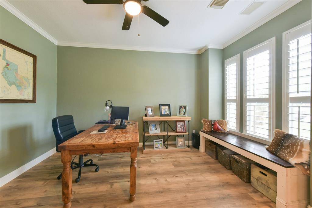 Right off of the entryway is a large home office with crown molding and plantation shutters.