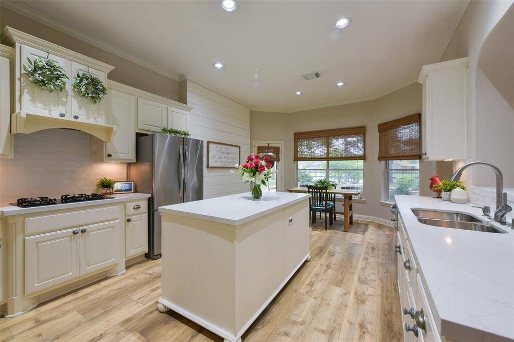 NEWLY UPDATED kitchen with beautiful quartz countertops and subway tile backsplash. Kitchen also features a four-burner gas stove and a huge center island. Notice the charming shiplap wall.