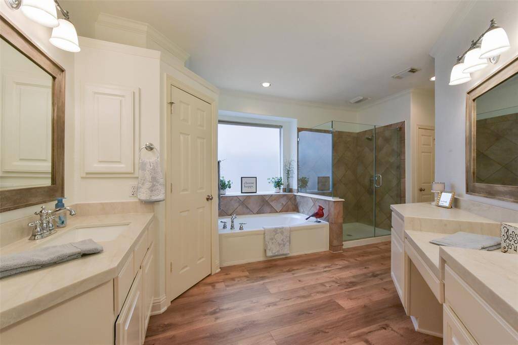NEWLY UPDATED primary bathroom with quartz countertops, durable LVP flooring, double sinks and even a vanity area.