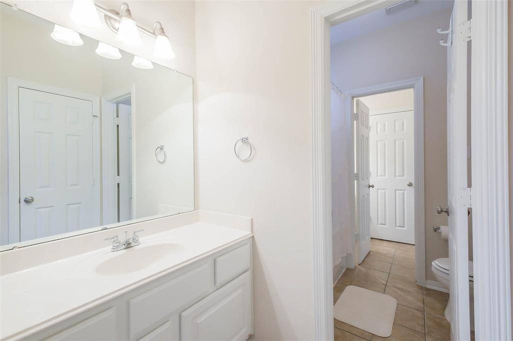 Jack and Jill bathroom shared between two of the upstairs bedrooms. Each bedroom has their own sink and vanity.