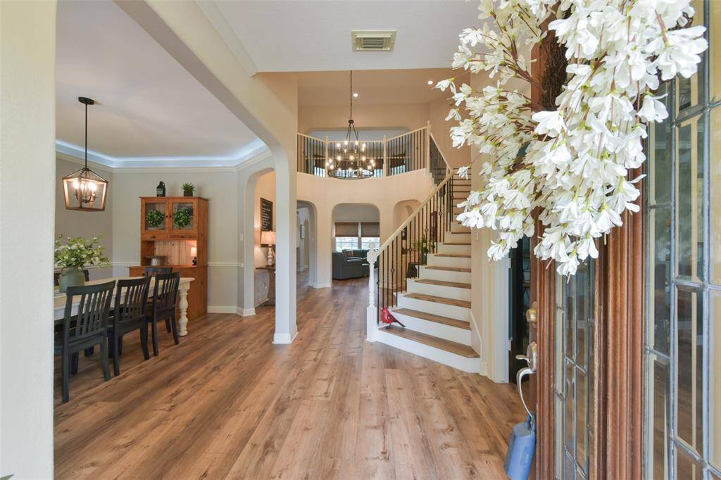 What an impressive entryway with updated lighting, high ceilings and a grand staircase.