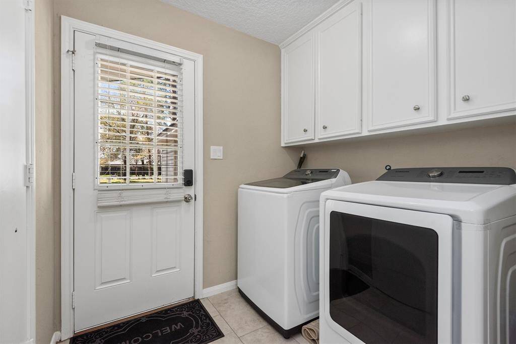 Utility room includes premium washer and dryer.