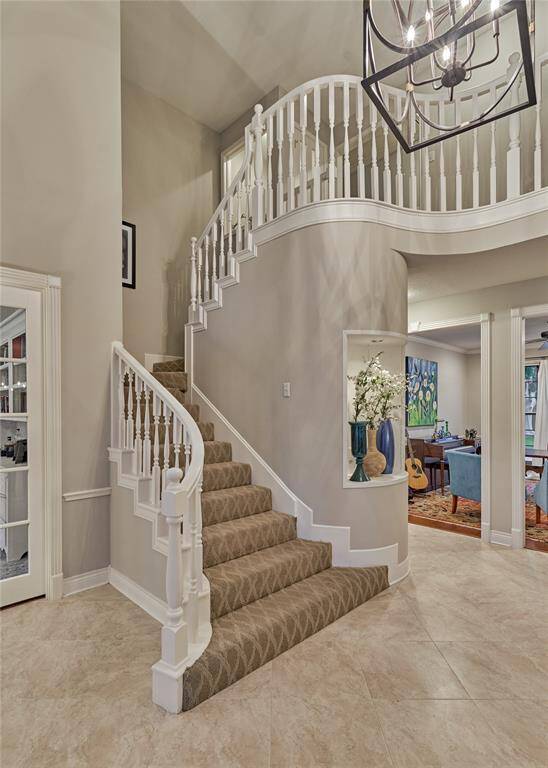 Elegant staircase with striking millwork and designer carpeting.