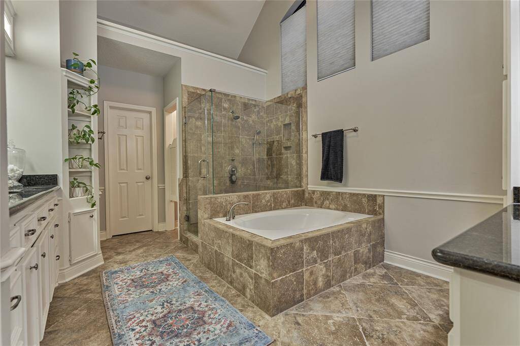 The spa-like primary ensuite features a soaking tub with tile-surround, a frameless walk-in shower and double vanities.