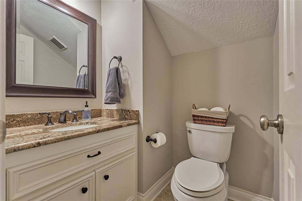 The downstairs half bath is down the hall near the second staircase.