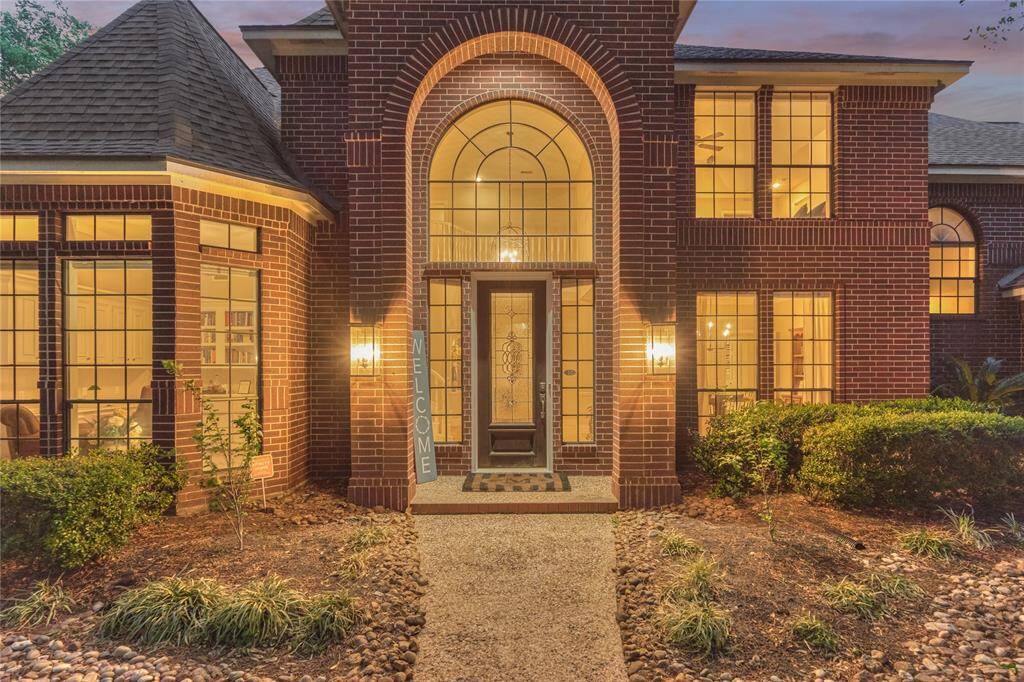 Stately arched entrance with wood and leaded glass door.