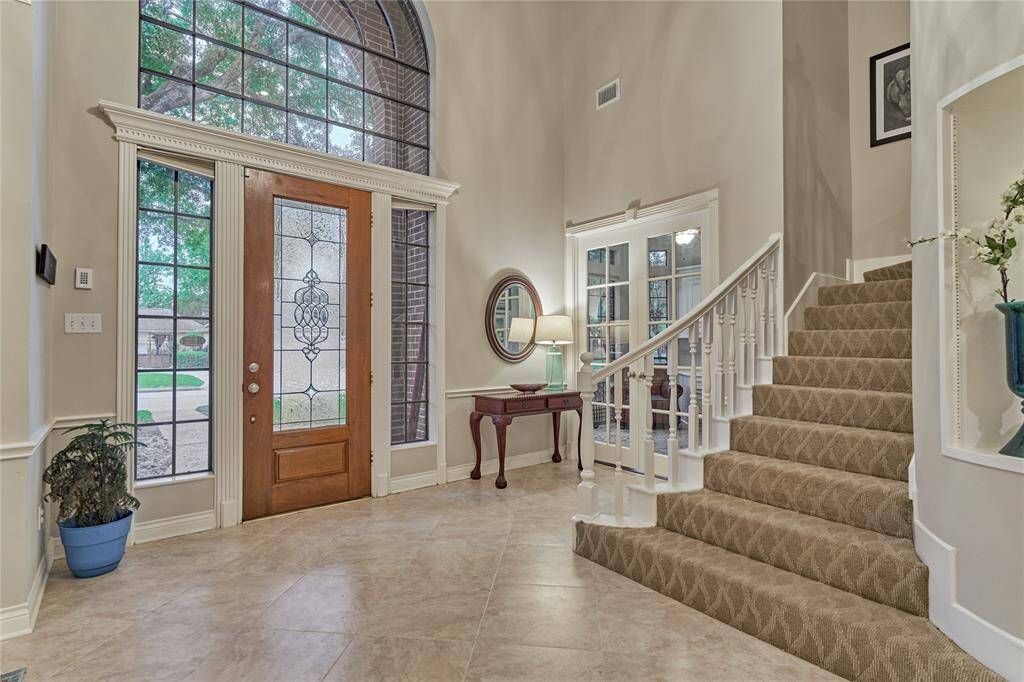 The stunning wall-of-windows lets an abundance of natural light pour through. The double French doors lead to a spacious study.