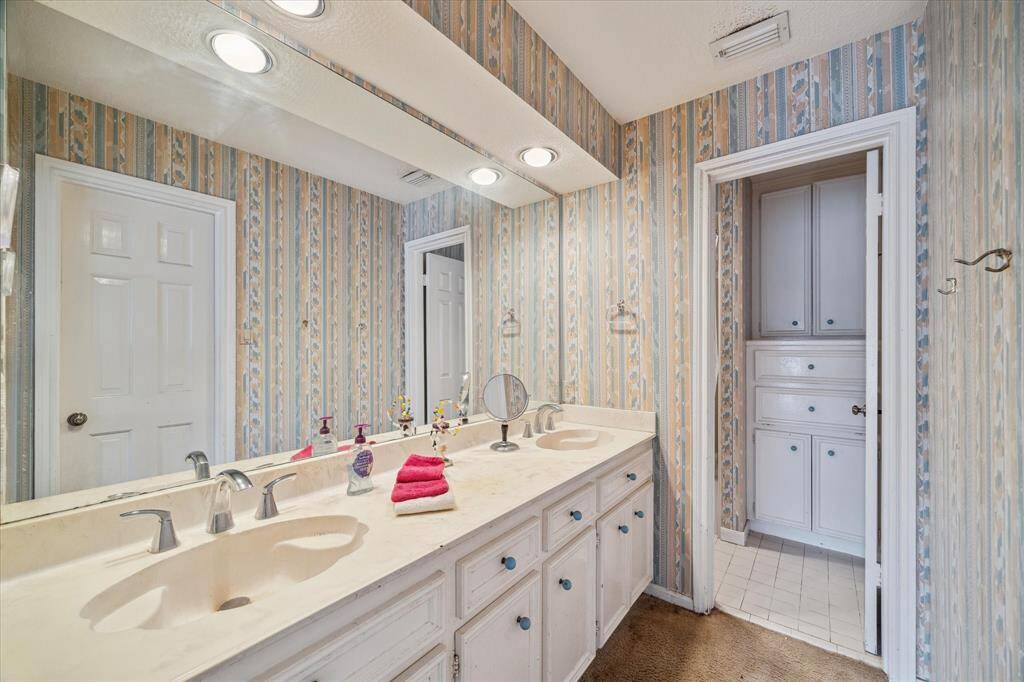 SECONDARY BATHROOM OFFERS DUAL SINKS AND SEPARATE TOILET AND SHOWER AREA.