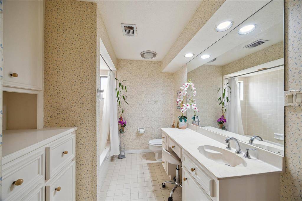 THIRD BATHROOM FEATURES A MAKEUP VANITY AND TUB/SHOWER COMBINATION.